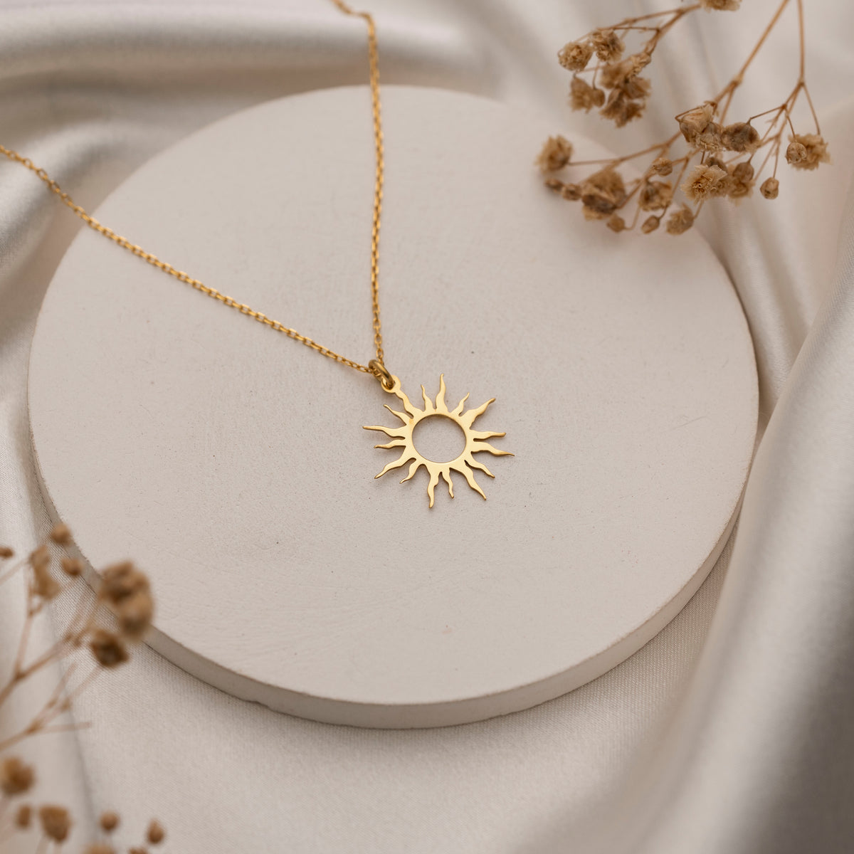 Close-up of delicate celestial sun pendant necklace